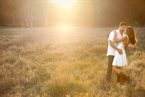 photo by Los Angeles wedding photographer Roberto Valenzuela - fun engagement photo of couple embracing in open field 